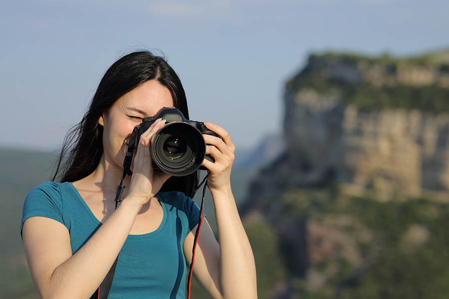 Asian tourist taking photos with dslr camera in the mountain